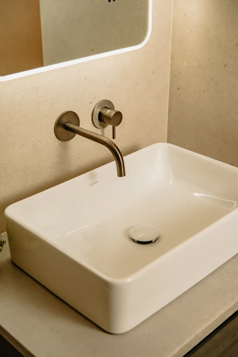Stone basin with wall-mounted brass tap